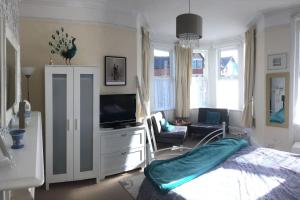 a bedroom with a bed and a tv and a living room at Turret Corner, Colwyn Bay, 5min walk to sandy beach in Conwy