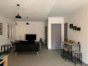 salon z kanapą, stołem i telewizorem w obiekcie Belle maison 100m2 avec terrasse et parking privé w Béziers