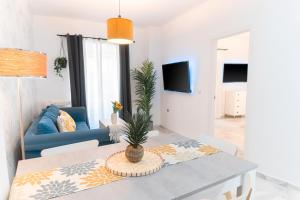 sala de estar con mesa y sofá azul en Downtown Apartment (4 bedrooms, 2 bathrooms, wifi), en Sevilla