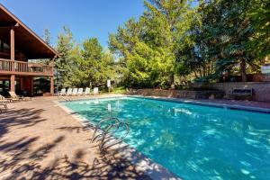 a swimming pool with chairs and a house at Big Views at Red Pine in Park City