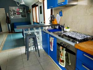 a kitchen with blue cabinets and a stove at THE ROOFTOP in Pero