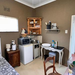 a small kitchen with a stove and a table at Farm stay at Thyme Cottage on Haldon Estate in Bloemfontein