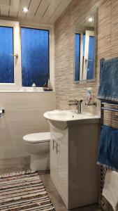 uma casa de banho com um lavatório, um WC e toalhas azuis em Chilowen - Happy House em Inverkeithing