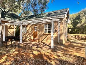 uma pequena casa com uma pérgula branca em Farm stay at Thyme Cottage on Haldon Estate em Bloemfontein