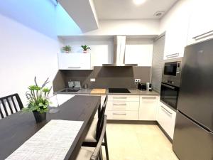 a kitchen with white cabinets and a black counter top at Casa Cousiño Zona Monumental in Pontevedra