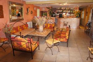 a living room with a table and chairs and a bar at Hotel Les Cavalets in Bauduen +34 photos