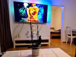 uma sala de estar com uma televisão de ecrã plano na parede em Good-And-Night em Neuss