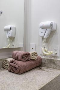 a bathroom with a blow dryer and a towel at Loft moderno Granja Brasil Coração de Itaipava in Itaipava