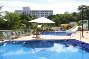 ein großer Pool mit Stühlen und einem Sonnenschirm in der Unterkunft Park Veredas - 1 Quarto - TURISMO in Rio Quente