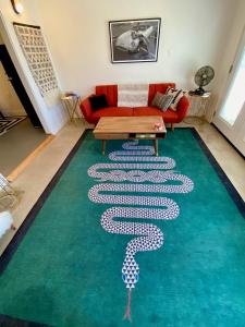 Sunburst House : Desert Chic Retreat في جوشوا تري: غرفة معيشة مع سجادة عليها تصميم ثعبان