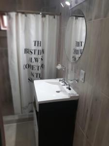 une salle de bain avec un lavabo et un miroir dans l'établissement Aires del Pipo, à Ushuaia 7 autres photos