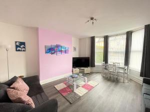 a living room with a couch and a tv at Marine Apartment Whitley Bay Seaside Location Free Onsite Parking in Whitley Bay