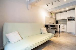 Una sala de estar con un sofá y una cocina. en Sun Studio, en Valbonne