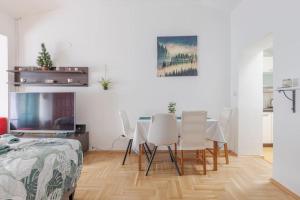 jadalnia ze stołem i białymi krzesłami w obiekcie Warm house full of green ambient,joy and comfort w Zagrzebiu
