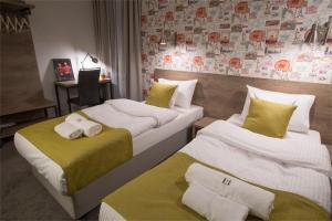 two beds in a hotel room with towels on them at MarcoPolo House in Warsaw