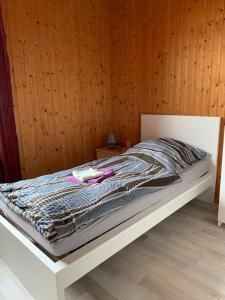 a bed in a room with a wooden wall at Monteurzimmer Ahnetal Zweibettzimmer Einzelzimmer mit eigenem Bad in Dörnberg