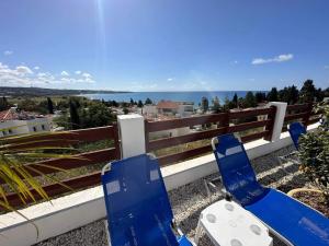 a pair of blue chairs sitting on a balcony overlooking the ocean at Villa Aqua Sunrise 1km From Beach With Sea Views in Coral Bay