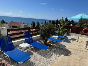 een rij blauwe stoelen en een parasol op een patio bij Villa Aqua Sunrise 1km From Beach With Sea Views in Coral Bay