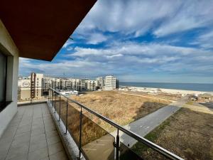 balcón con vistas a la playa y a los edificios en Vedere la mare apartament, en Mamaia