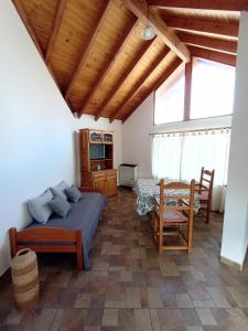 een slaapkamer met een bed en een tafel en stoelen bij La Casita in Esquel