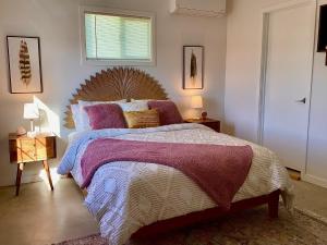 Sunburst House : Desert Chic Retreat في جوشوا تري: غرفة نوم بسرير كبير مع اللوح الخشبي