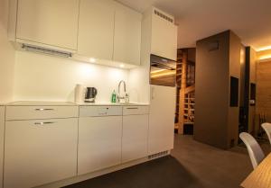 eine weiße Küche mit weißen Schränken und einem Waschbecken in der Unterkunft Residenz Montfort SIVI150 in Siviez