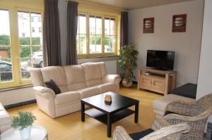 a living room with a couch and a tv at Villa Mowgli in De Panne