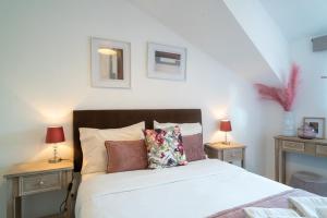 um quarto com uma cama com duas mesas de cabeceira e dois candeeiros em Porto River House no Porto