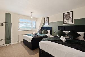 a bedroom with two beds and a window at Stylish Abode with Games Room - Sleeps 15 in Brislington