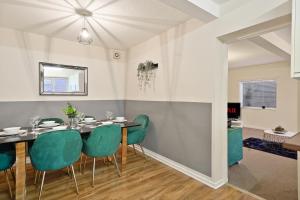 een eetkamer met een tafel en groene stoelen bij Stylish Abode with Games Room - Sleeps 15 in Brislington