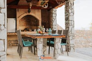 an outdoor kitchen with a wooden table and chairs at Villa Hlapa-new modern villa near beach - by TRAVELER tourist agency Krk in Gostinjac