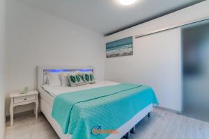 a white bedroom with a bed with a blue blanket at Villa Hlapa-new modern villa near beach - by TRAVELER tourist agency Krk in Gostinjac +32 photos