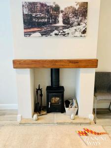 a fireplace in a living room with a picture on the wall at Bleabeck View, Middleton-In-Teesdale in Middleton in Teesdale