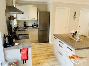 uma cozinha com um frigorífico em aço inoxidável e pisos em madeira em Bleabeck View, Middleton-In-Teesdale em Middleton in Teesdale
