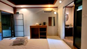 a room with a bed and a bathroom with a sink at Cassiopeia Srithanu Apartments in Srithanu