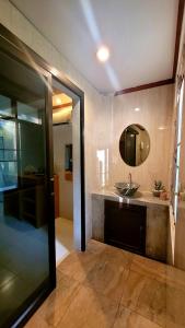 a bathroom with a sink and a mirror at Cassiopeia Srithanu Apartments in Srithanu