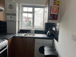 a kitchen with a washing machine and a window at Spacious 3 Bed Flat in Greenwich in London