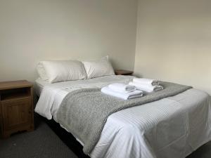 een slaapkamer met een bed met handdoeken erop bij Spacious 3 Bed Flat in Greenwich in Londen