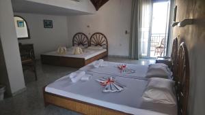 a room with three beds with towels on them at Marina Studios I in Argostoli