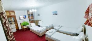 a small room with two beds and a chair at AISHA Hotel in Samarkand