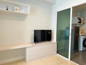 Condo-Wutthakard في بانكوك: تلفزيون بشاشة مسطحة جالس على رف في غرفة معيشة