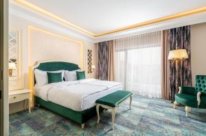 a bedroom with a green bed and a green chair at Hotel Leul de Aur in Sebeş +68 photos