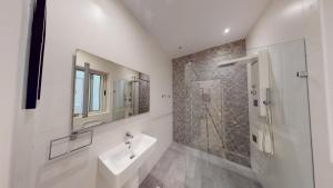 a white bathroom with a sink and a shower at Spacious 3 bedroom maisonette in Sliema +13 photos