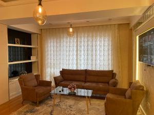 a living room with a couch and two chairs and a table at Park Azure apartment Baku in Baku