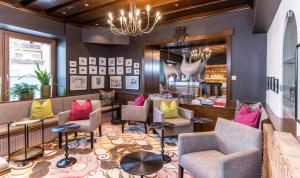 a lobby of a restaurant with colorful chairs and tables at Hotel Moserhof in Seeboden