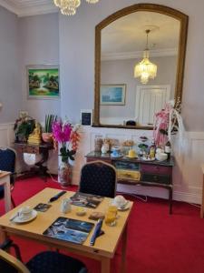 a living room with a table and a mirror at Bluebells guest house in Barmouth