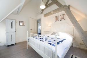 ein Schlafzimmer mit einem weißen Bett und einer Treppe in der Unterkunft Alta Mar Studios in Scheveningen