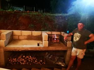 a man is standing in front of a grill at Treur River Lodge in Moremela