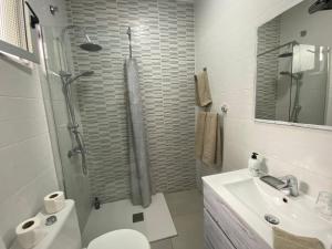 a bathroom with a toilet and a sink and a shower at Casa Kevin in Puerto de Mogán +21 photos