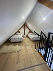 two beds in a loft with a wooden floor at Chaleur Moderne des Pyrénées in Argelès-Gazost